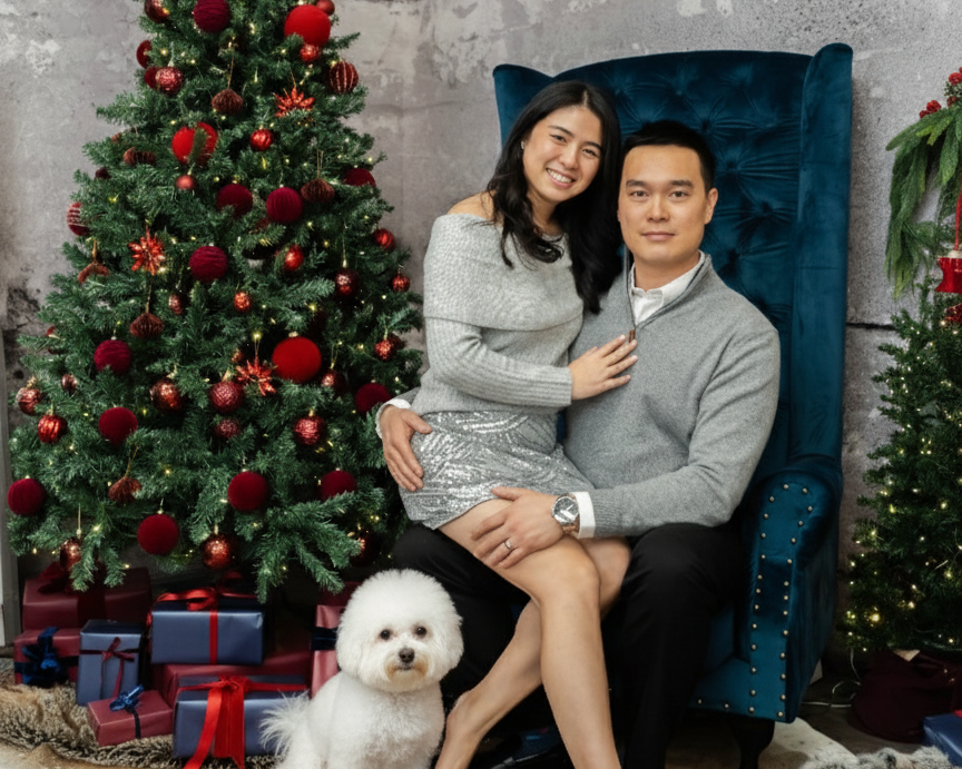 Pet gift box owners sitting together with a dog in front of a decorated Christmas tree.